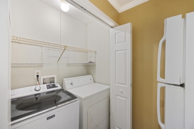 clothes washing area with washer and dryer and ornamental molding