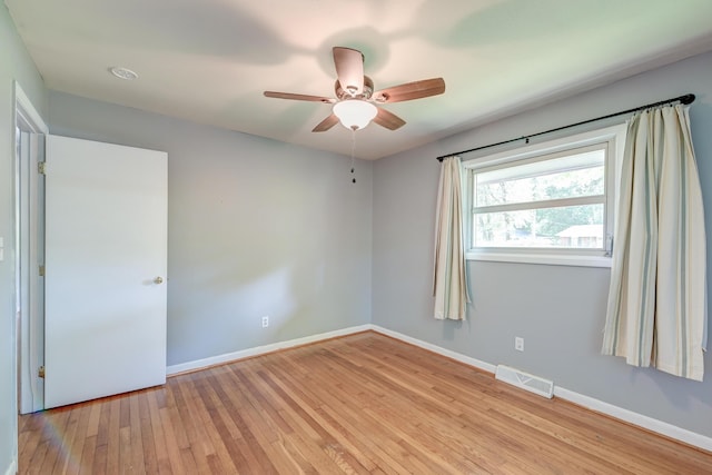 unfurnished room featuring visible vents, light wood finished floors, ceiling fan, and baseboards
