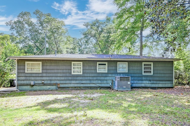 back of property featuring central AC and a yard
