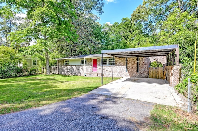 ranch-style house featuring fence, a front lawn, and aphalt driveway