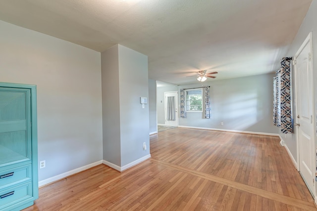 unfurnished room featuring baseboards, ceiling fan, and light wood-type flooring