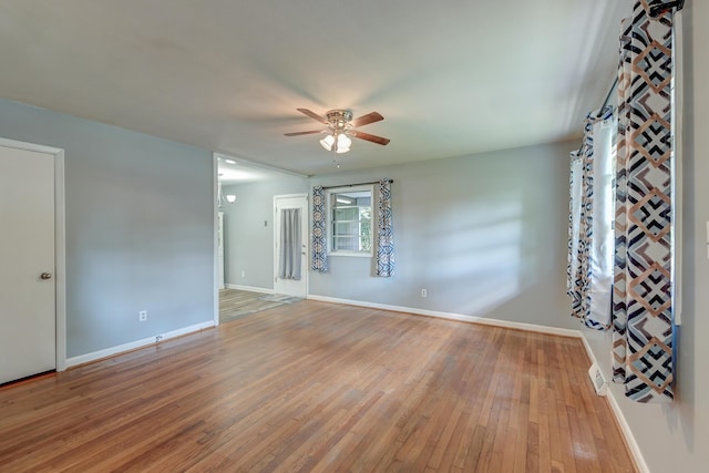 empty room featuring baseboards, ceiling fan, and light wood-type flooring