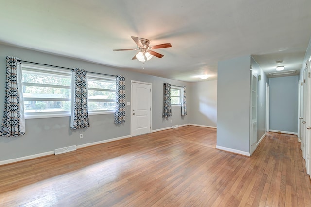 interior space featuring visible vents, a ceiling fan, baseboards, and wood finished floors