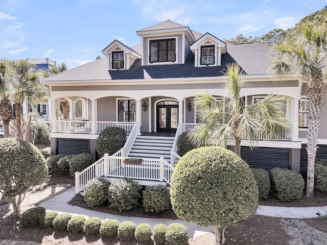 coastal inspired home featuring a porch, a shingled roof, and stairs