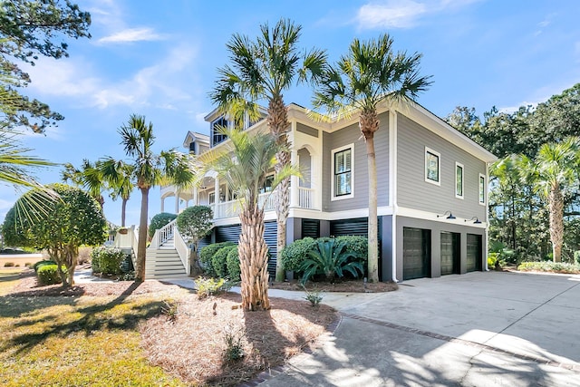 exterior space featuring driveway, an attached garage, and stairs