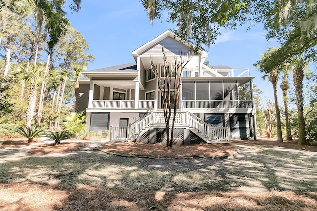 rear view of property with stairs and a sunroom