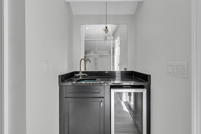 bar featuring indoor wet bar, beverage cooler, decorative light fixtures, and a sink