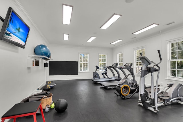 workout area featuring visible vents, ornamental molding, and baseboards