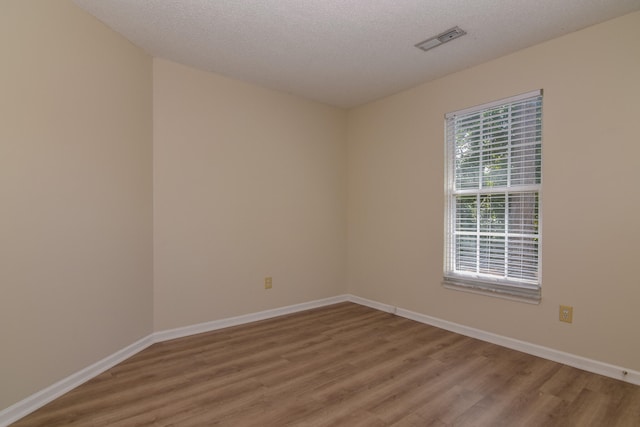 spare room with hardwood / wood-style floors and a textured ceiling