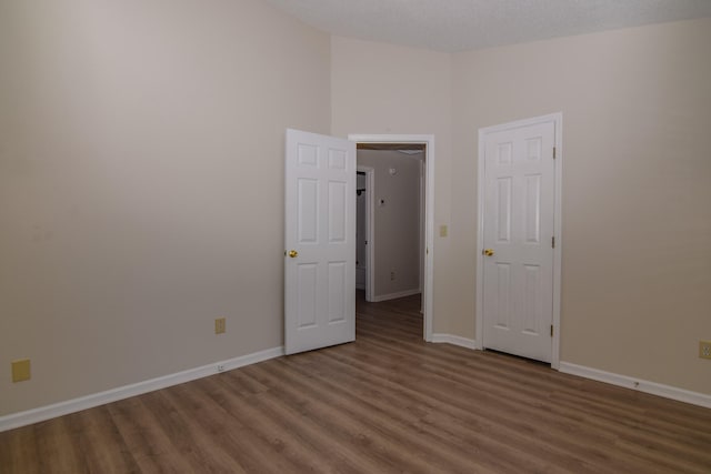 unfurnished room with dark wood-type flooring and a textured ceiling