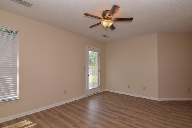 empty room with ceiling fan, a textured ceiling, and hardwood / wood-style floors