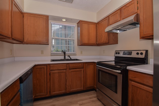 kitchen with sink, a textured ceiling, stainless steel appliances, light hardwood / wood-style flooring, and exhaust hood