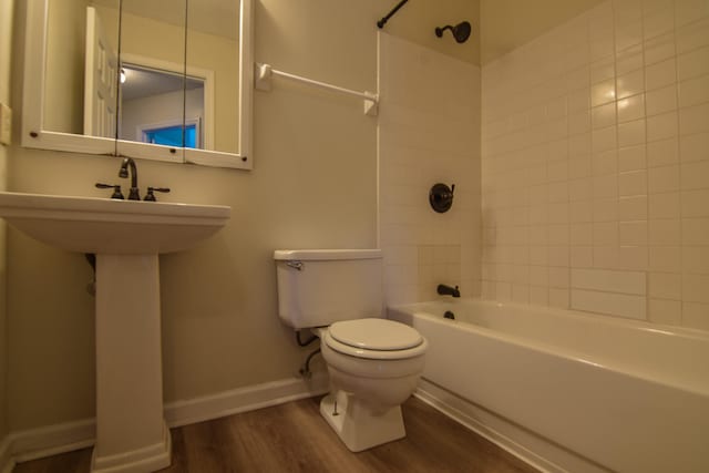 bathroom featuring toilet, hardwood / wood-style flooring, and tiled shower / bath combo