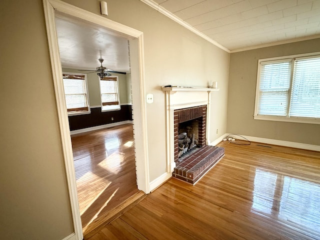 unfurnished living room featuring hardwood / wood-style floors, ceiling fan, a healthy amount of sunlight, and a fireplace