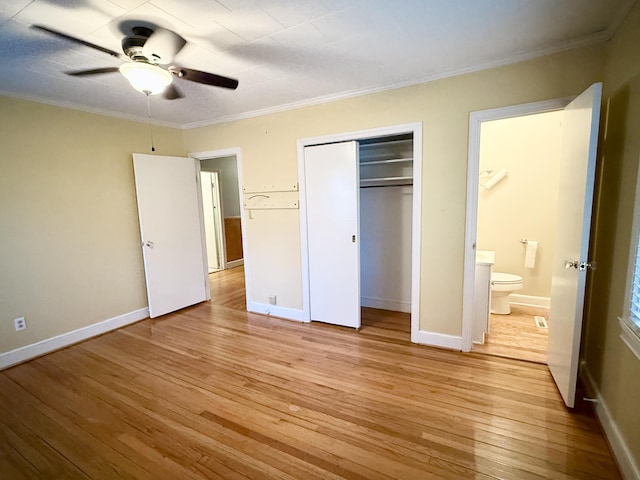 unfurnished bedroom with ensuite bathroom, crown molding, ceiling fan, light hardwood / wood-style floors, and a closet