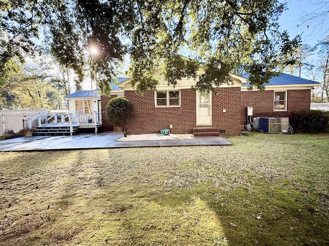 back of house featuring a lawn, a deck, a patio, and central AC