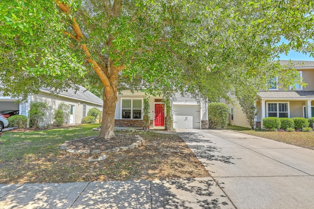 obstructed view of property with concrete driveway and stone siding