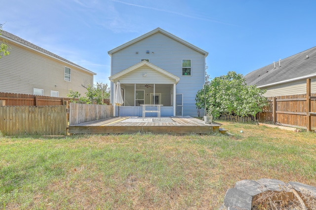 rear view of house with a fenced backyard, a ceiling fan, a wooden deck, and a yard