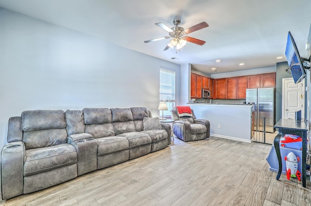 living room with recessed lighting, ceiling fan, and light wood-style flooring