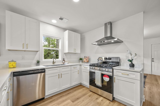 217 Quaker Rd, Saint George, SC 29477 - kitchen with appliances with stainless steel finishes, wall chimney exhaust hood, a sink, white cabinetry, and light countertops