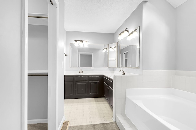 bathroom with vanity, a bathing tub, and a textured ceiling