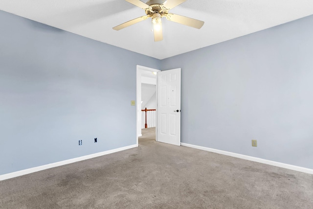 carpeted spare room featuring ceiling fan