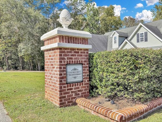 community sign featuring a yard