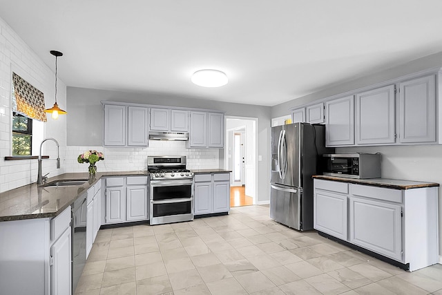 kitchen featuring appliances with stainless steel finishes, gray cabinets, tasteful backsplash, and sink