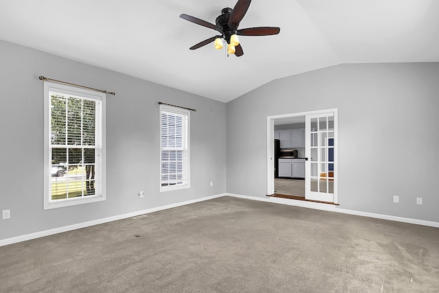 carpeted spare room featuring vaulted ceiling and ceiling fan