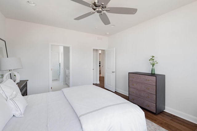 bedroom featuring a ceiling fan, baseboards, ensuite bathroom, visible vents, and dark wood-style floors