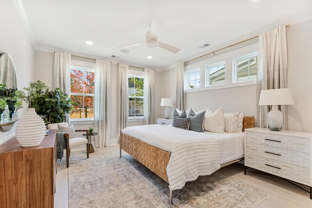 bedroom with ceiling fan, light hardwood / wood-style floors, and crown molding