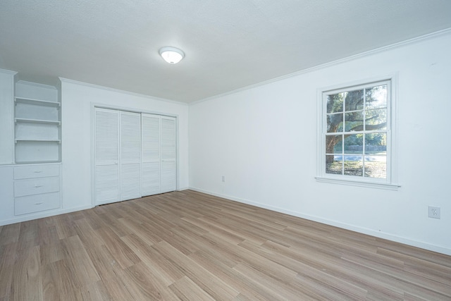 unfurnished bedroom featuring crown molding, light hardwood / wood-style floors, and a textured ceiling