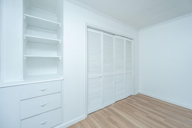 unfurnished bedroom featuring crown molding, a closet, and light hardwood / wood-style floors