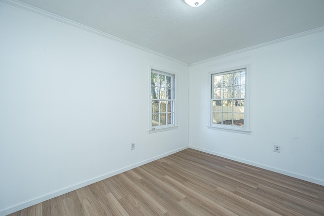 spare room with light hardwood / wood-style floors, a textured ceiling, and ornamental molding