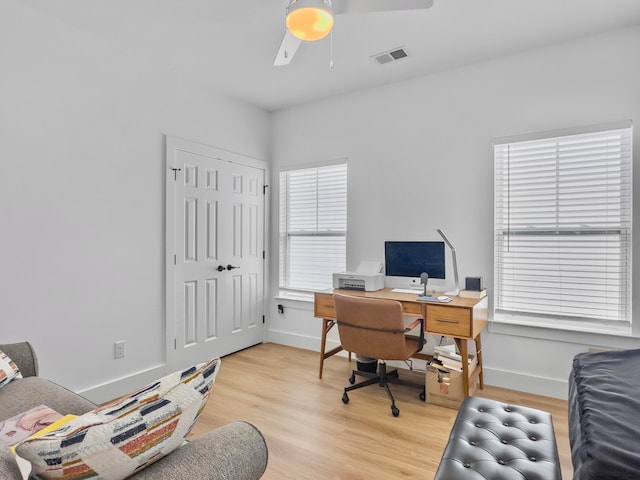 home office with light hardwood / wood-style flooring and ceiling fan