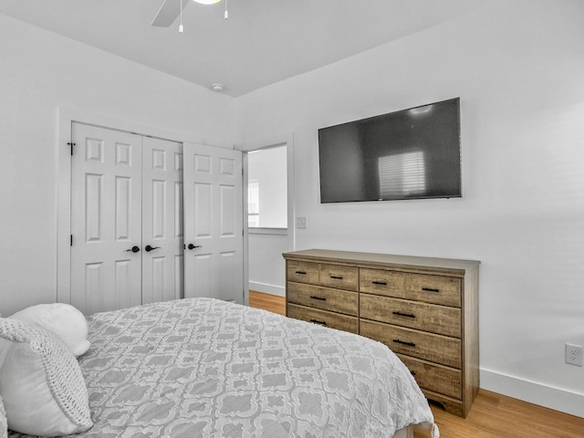 bedroom with light wood-type flooring, a closet, and ceiling fan