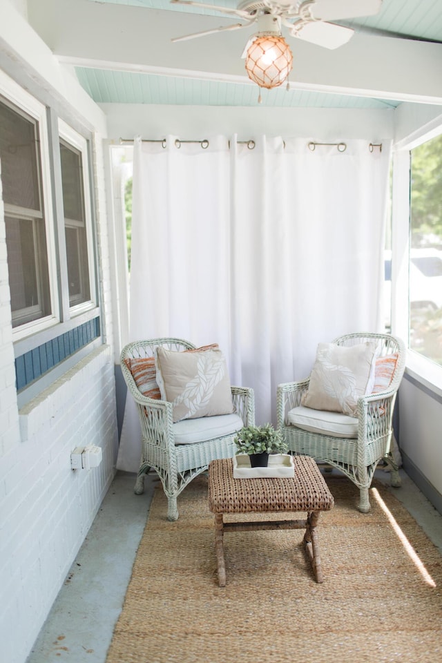 sunroom with beamed ceiling and ceiling fan