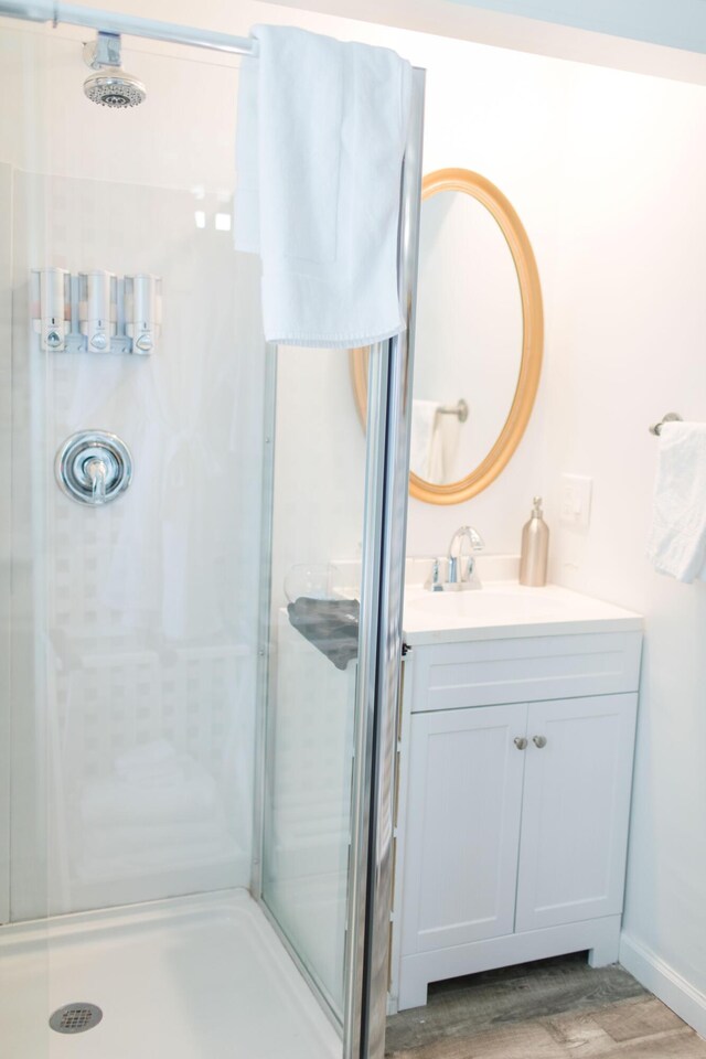 bathroom featuring vanity, an enclosed shower, and hardwood / wood-style flooring