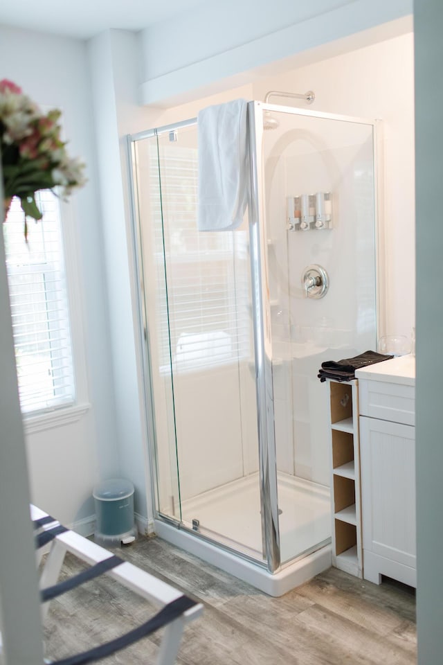 bathroom featuring hardwood / wood-style flooring, vanity, and an enclosed shower