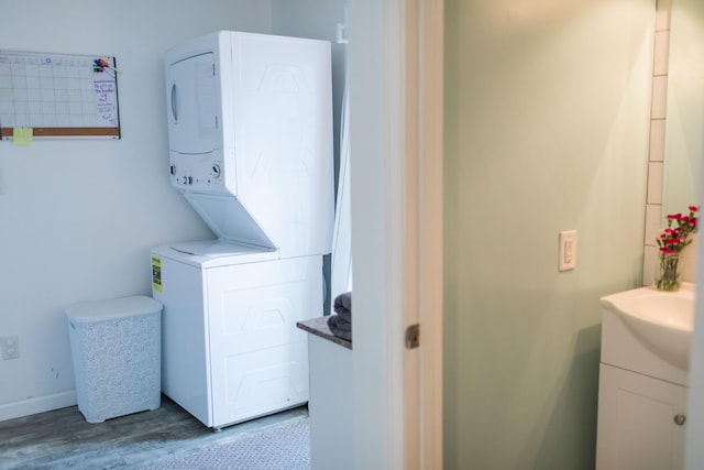 laundry room featuring light hardwood / wood-style floors and stacked washing maching and dryer