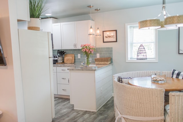 kitchen featuring pendant lighting, white fridge, dark hardwood / wood-style flooring, and white cabinetry