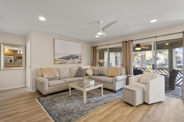 living room with ceiling fan and light hardwood / wood-style floors