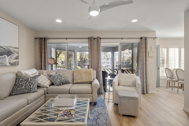 living room featuring ceiling fan and light hardwood / wood-style flooring