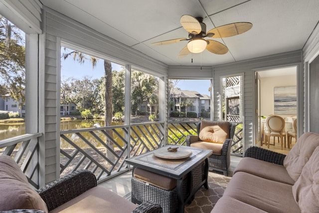 sunroom / solarium featuring a water view and ceiling fan