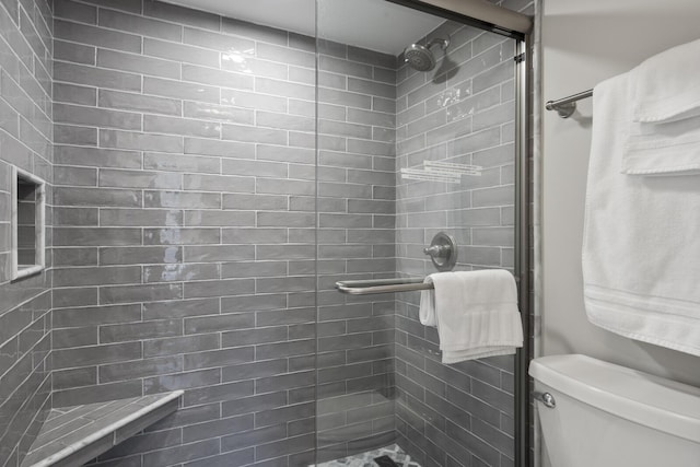 bathroom featuring an enclosed shower and toilet