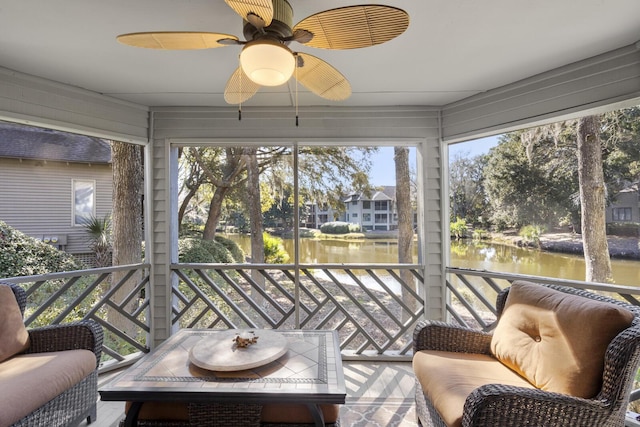 sunroom / solarium featuring ceiling fan and a water view