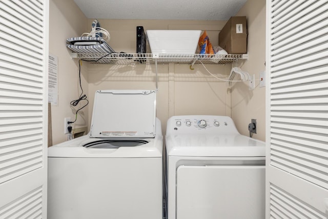 laundry room with washing machine and clothes dryer and a textured ceiling