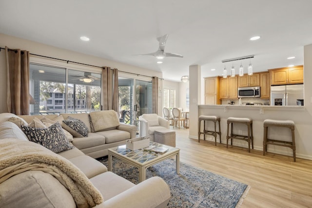 living room featuring ceiling fan and light wood-type flooring