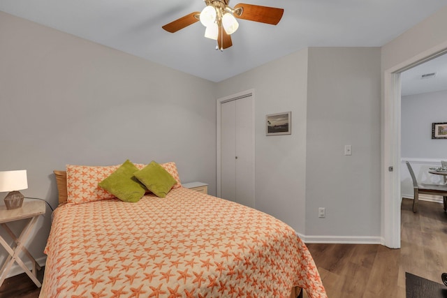 bedroom featuring a closet, dark hardwood / wood-style floors, and ceiling fan