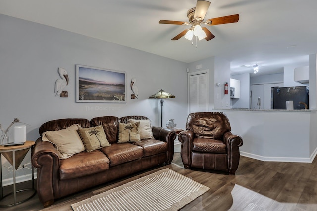 living room featuring ceiling fan and dark hardwood / wood-style flooring